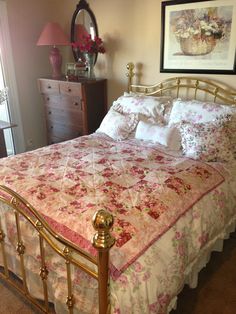 a bed with pink and white bedspread in a bedroom next to a dresser