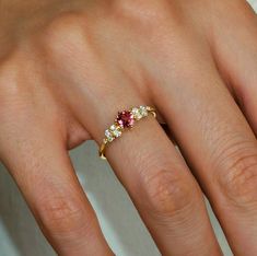 a woman's hand with a ring on it and two stones in the middle