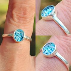 two rings with blue topazs are shown on someone's finger and one has a diamond in the middle