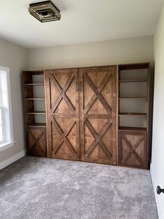 an empty room with wooden doors and shelves