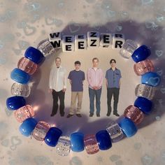 a bracelet with three men standing in front of the word weezer written on it