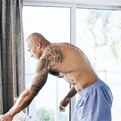 a man in blue shorts cutting a cake