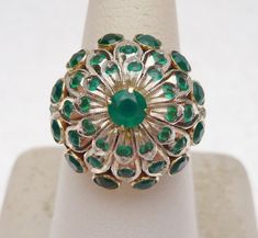 This is a very interesting piece. These were very popular in the 1950's and 1960's. This is a Thai Princess style ring made of 10 karat yellow gold and sterling silver. The stones are round cut green Onyx. All stones are prong and bezel set throughout the ring, and there is a larger round green onyx that sits on the top of the ring in a 4 prong head. The base of the ring is 10 karat yellow gold and the top of the ring is sterling silver. Ring is a size 7. *Sizing is available. Please message us Art Deco Round Green Emerald Ring, Art Deco Emerald Ring With 17 Jewels, Vintage Green Emerald Ring With Multi-stone, Vintage Multi-stone Green Emerald Ring, Green Dome Ring For Anniversary In Fine Jewelry Style, Green Dome Ring For Anniversary, Fine Jewelry, Vintage Multi-stone Emerald Ring, Antique Multi-stone Round Emerald Ring, Antique Round Multi-stone Emerald Ring