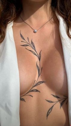 a woman with tattoos on her chest is posing for the camera