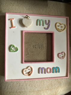 a pink and white photo frame with magnets on the front that says, i love my mom