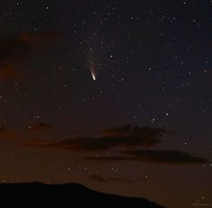 the night sky is filled with stars and bright lights, as well as some clouds