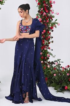 Midnight blue attached cancan ruffed lehenga saree with all over crystal drops embellishments and an attached drape. Paired with a backless halter neck padded blouse with multi colored sequins bloom embroidery. - Aza Fashions Ruffled Dresses For Navratri, Festive Draped Choli With Ruffles, Festive Draped Ruffle Choli, Festive Draped Ruffles Choli, Festive Draped Ruffled Choli, Fitted Draped Sharara With Pallu, Ruffled Dupatta For Navratri Reception, Summer Reception Georgette Sharara, Ruffled Dupatta For Reception And Navratri