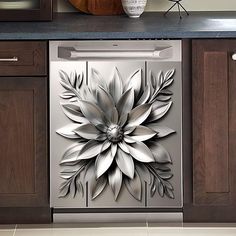 a metal flower on the side of a dishwasher in a kitchen