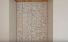 the corner of a room with a wooden ceiling and wallpaper on it, featuring an arrow pattern