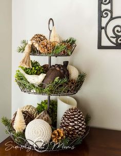 three tiered tray with pine cones and other decorations