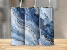 three blue and gold canisters sitting on top of a wooden table