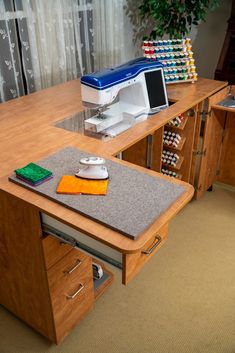 a sewing machine sitting on top of a wooden desk next to a drawer filled with crafting supplies