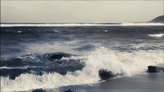 an ocean scene with waves crashing on the shore