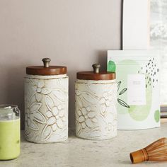 three canisters sitting on a counter next to a window