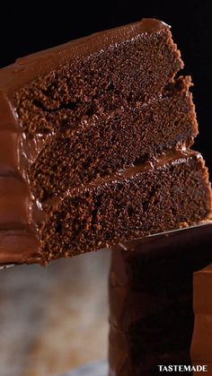 a piece of chocolate cake on top of a wooden spatula with one slice taken out