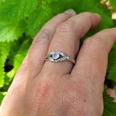 This magical rainbow moonstone ring enchants the senses with its prismatic stone surround by tiny leaves set on a band that looks like it was forged within an enchanted forest. Each ring is handmade specifically for you where a hand-wrought recycled sterling silver split-shank band is adorned with tiny detailed leaves that surround a round faceted rainbow moonstone that reflects the light with unexpected flashes of color. This nature-inspired rainbow moonstone ring could be a non-traditional gem Promise Rings With Birthstone And Moonstone, Spiritual Sterling Silver Moonstone Promise Ring, Ethereal Moonstone Rings With Birthstone, Mystical Moonstone Rings With Birthstone, Nature-inspired Moonstone Ring, Nature-inspired Sterling Silver Moonstone Promise Ring, Nature-inspired Round Moonstone Ring In Sterling Silver, Mystical Moonstone Rings For Promise, Nature-inspired Moonstone Rings For Gifts