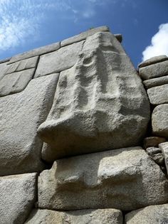 a large stone structure with carvings on it's face and hands carved into the rock