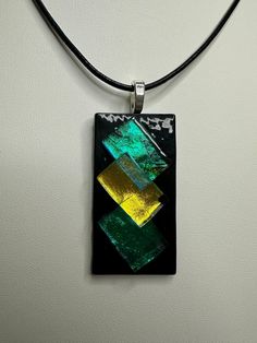 This stunning dichroic glass necklace is handmade by yours truly here in Eau Claire, Wisconsin. This beautiful one-of-a-kind piece measures 2" in height, and 1" in width. Each piece is topped with a sterling silver plated bail and comes with a 20" black leather cord upon purchase. Unique Rectangular Glass Jewelry, Handmade Glass Jewelry With Rectangular Pendant, Handmade Glass Rectangular Pendant Jewelry, Handmade Rectangular Glass Jewelry, Glass Necklaces With Rectangular Pendant For Gift, Glass Necklace With Rectangular Pendant For Gift, Modern Murano Glass Jewelry As Gift, Modern Murano Glass Jewelry Gift, Handmade Glass Square Pendant Jewelry