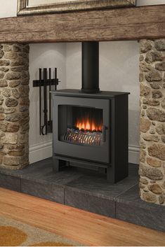 a wood burning stove sitting inside of a living room next to a mirror on the wall