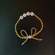 a beaded bracelet with the word boo spelled in white beads and a bow on it