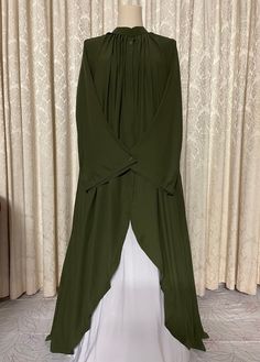 Soft lightweight olive green long abaya cape with designed collar and buttoned neck. Front open cape/stole with nice flare for a flowy and stylish look and ease of walking. A nice touch to your simple abaya or suit look.  Fabric and style suitable for all occasions and weather conditions.  Abaya cape may be worn with any color abaya or salwar or dress suit of your choice.  Available in size 52. This item comes as cape ONLY, it does not come with under abaya as shown in images.  (You may purchase linen abayas separately of your color choice from the shop.) Traditional Long Green Abaya, Abaya Cape, Elegant Green Embroidered Abaya, Color Abaya, Green Fitted Long Sleeve Abaya, Green Embroidered Long Sleeve Abaya, Green V-neck Abaya, Simple Abaya, Head Coverings