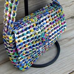 a multicolored purse sitting on top of a wooden floor