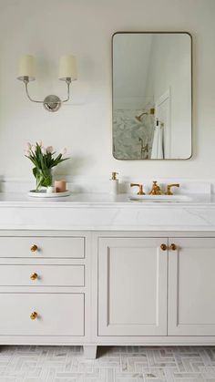 a white bathroom with two sinks and mirrors on the wall next to eachother