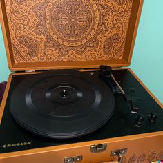 an old record player sitting on top of a suitcase