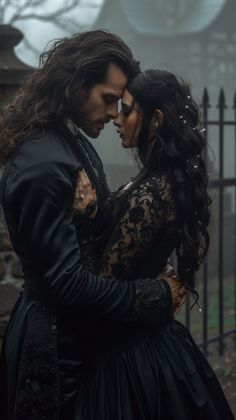 a man and woman dressed in black embracing each other