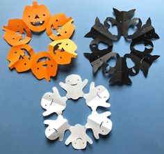 several different shapes and sizes of halloween decorations on a blue surface with black, orange, and white paper