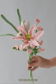 a person is holding a crocheted pink flower in their left hand, and the flowers are on top of each other