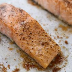 a piece of salmon sitting on top of a pan covered in seasoning sprinkles