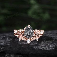 a rose gold engagement ring set with a pear shaped diamond surrounded by leaves and diamonds