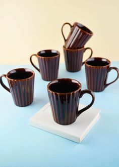 five coffee cups sitting on top of a blue table