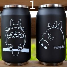 two black stainless steel mugs with totoro drawings on them