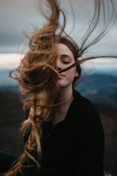 a woman with her hair blowing in the wind