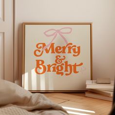 an orange merry and bright sign sitting on top of a wooden floor next to a bed