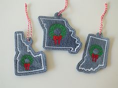 three christmas ornaments hanging from red and white twine on a table with candy canes