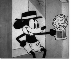 a mickey mouse holding a beer in front of a wall with a drawing on it