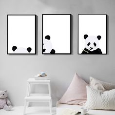 three black and white panda bears hanging on the wall next to a small table with a teddy bear