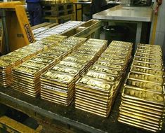 stacks of gold bars are stacked on top of each other in an assembly line at a factory