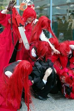 several people dressed in red and black with long hair