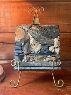 a rock and metal stand on a wooden table