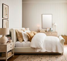 a white bed sitting in a bedroom on top of a wooden floor next to a dresser