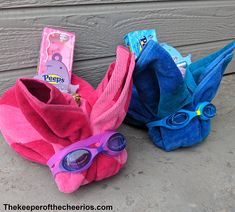 two blue and pink towels, one with purple goggles, the other without glasses