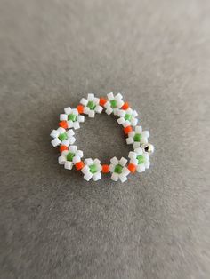 Beaded stretch Flower Ring - White, Orange, Green Color : White, Orange, Green Size : about 20mm Ring Size : one size ( fit for size 6 to 7 ) Materials : Seed bead, Acrylic bead * Metal components seed bead, acrylic bead. * Comes in a jewelry box. If you need extra boxes for gifting....just let us know! Spring White Flower Ring As A Gift, White Flower Ring For Spring Gift, White Flower Ring For Spring, Handmade White Flower Ring For Spring, Handmade Adjustable White Flower Ring, White Flower Ring Perfect For Gifts, Spring White Flower Ring, White Beaded Flower Ring As Gift, White Beaded Rings