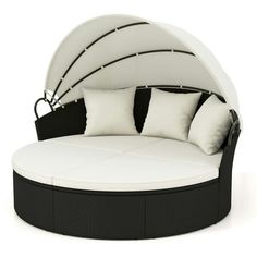 an outdoor daybed with white cushions and black trimmings on the bed frame