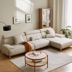 a living room with a sectional couch and coffee table in front of a large window