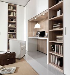 a white chair sitting in front of a book shelf next to a desk with a laptop computer on top of it