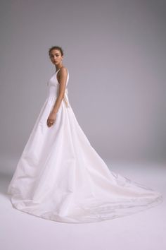 a woman in a white wedding dress posing for a photo with her hands on her hips